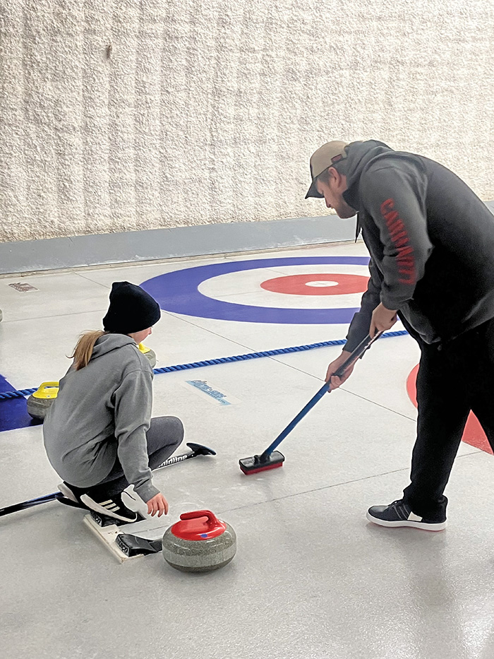 Paul Bickerton helping a curler get ready to deliver her rock.”></a><br />
<p class=